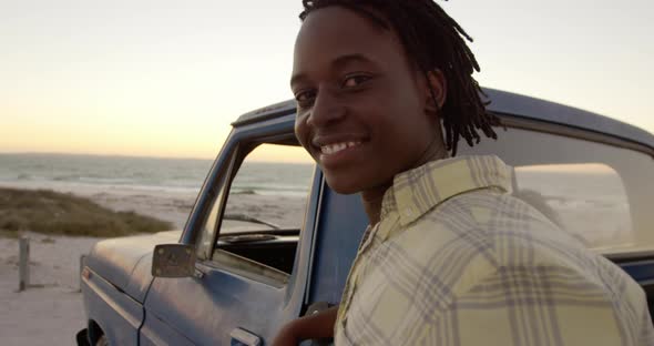 Man looking at camera near pickup truck at beach 4k