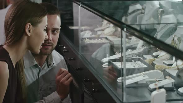 Couple Choosing Wedding Ring on Luxury Shop Display