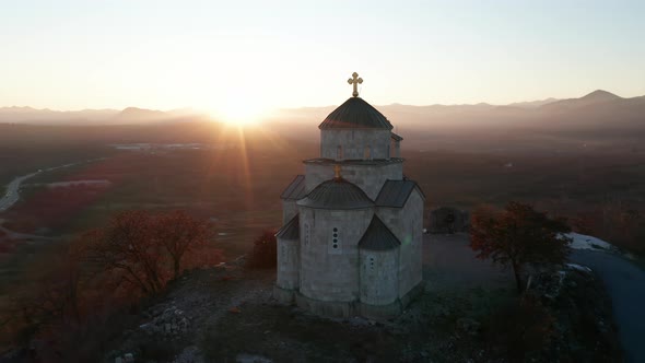 Small limestone christian church on top of a hill, at sunset