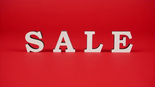 White Letters Rotating on the Red Background and Forming the Word Sale. Stop Motion Animation