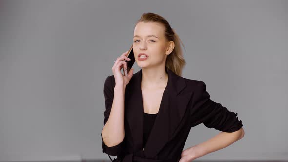 çConfident Businesswoman Talking on Smartphone