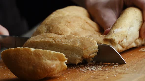 A Woman Cutting a Loaf of Bread with a Bread Knife
