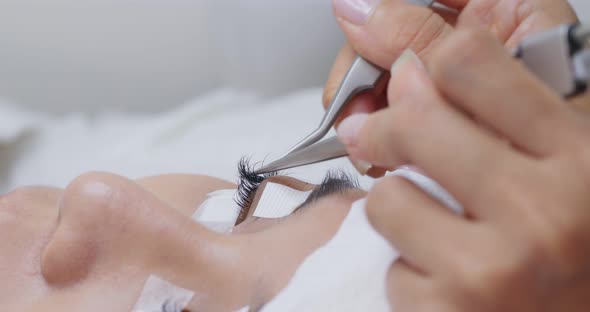 Woman having eye lash extension process