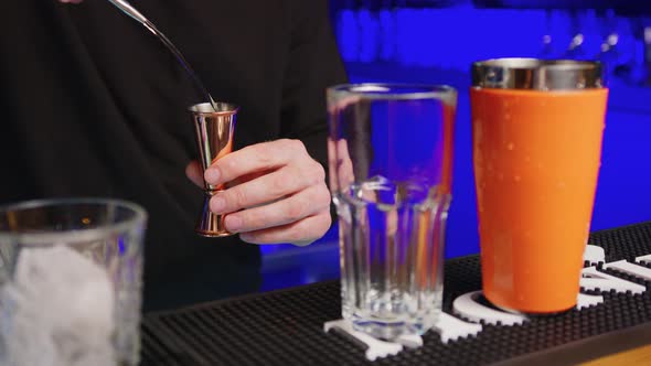 Closeup of Bartender Pouring Drink Into the Glass