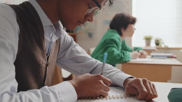 Black Guy Writing in Notebook on Lesson