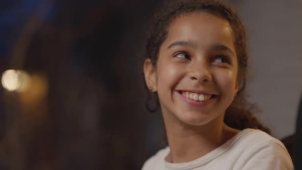 Closeup Face of Joyful Smiling African American Girl Smelling and Biting Delicious Cooked Burger