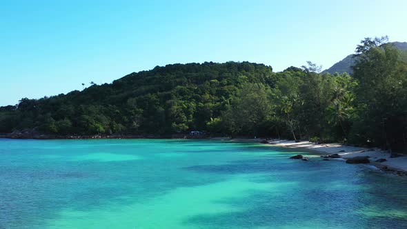 Tropical birds eye clean view of a sunshine white sandy paradise beach and aqua blue ocean background