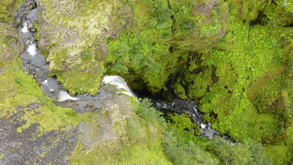 Drone Fly Over Narrow River Flowing On Steep Mountains In Nauthúsagil Waterfall, Iceland. Aerial