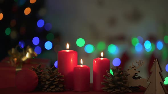 Candles Burning Near Wooden Christmas Decorations Lights Sparkling on Background