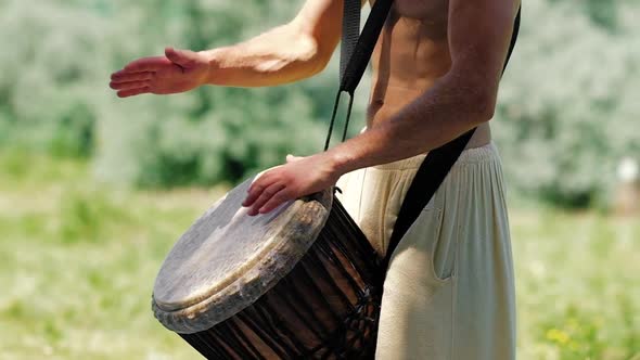 Unidentified Caucasian Man Playing African Djembe Drum