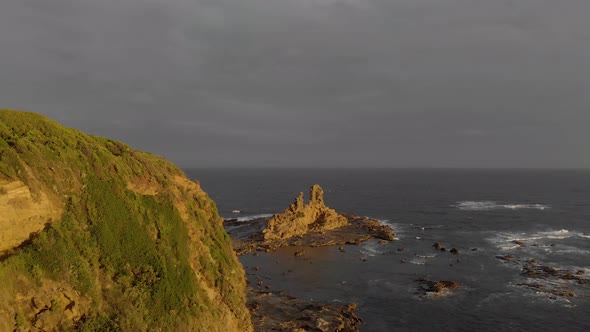 A forward moving aerial of the golden glow of the sun reflecting on cliffs and on the eagles nest ro