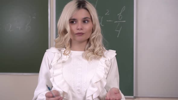 Portrait of a Young Attractive Female School Teacher During a Lesson in the Classroom