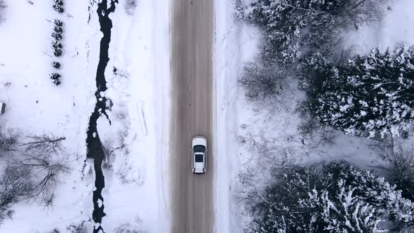 Aerial View of the Car Moving Forward By Snowed Road