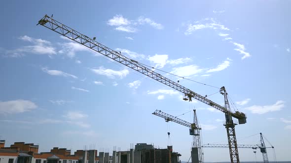 High industrial tower crane at construction site of new residential building.