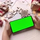 Child holding smartphone with horizontal green screen on Christmas background with gifts. - VideoHive Item for Sale