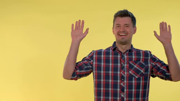 Happy Young Man Covering His Face with Hands, Then Opening It and Smiling.