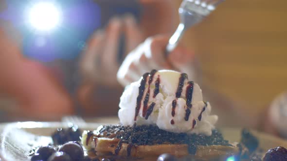 Woman making mobile photo of dessert with ice cream