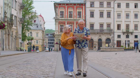 Senior Stylish Couple Tourists Man Woman Grandmother Grandfather Looking for Way Using Paper Map
