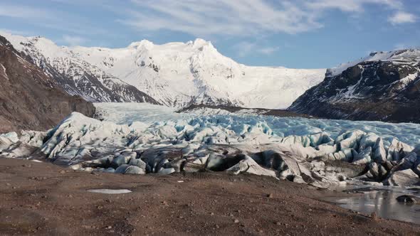 Drone Towards Large Glacier With Snow Covered Mountains