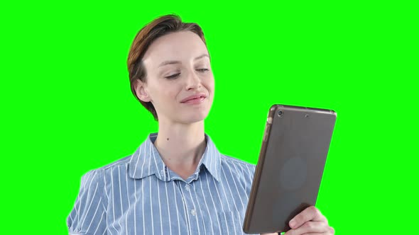 Caucasian woman using a digital tablet on green background