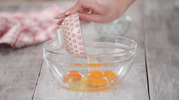 Woman Hands Putting Sugar and Eggs in Bowl. Baking Concept