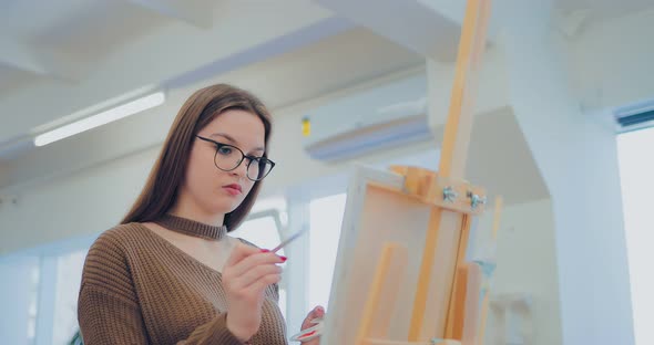 Artist Is Passionate About the Work on the Picture. Girl Draws in the Studio