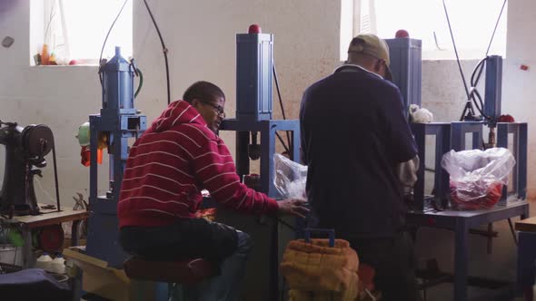 Two mixed race men discussing in factory