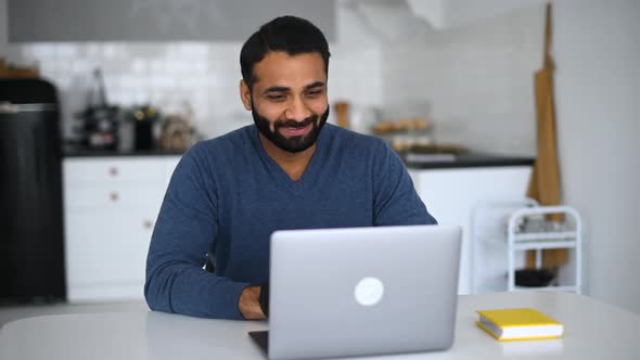 Young Indian Male Employee is Using Video Connection for Virtual Meeting with Coworkers