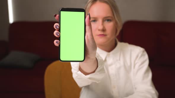 Stock Video Woman Showing Smartphone with Empty Green Screen Chromakey at Home