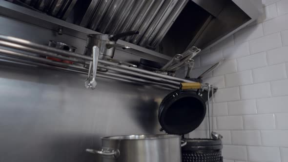 Tilt Down of Large Pot on Stove and Appliances in Restaurant Kitchen