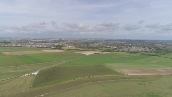 Aerial tracking north from Maiden Castle, the towns of Dorchester and Poundbury is visible in the ba