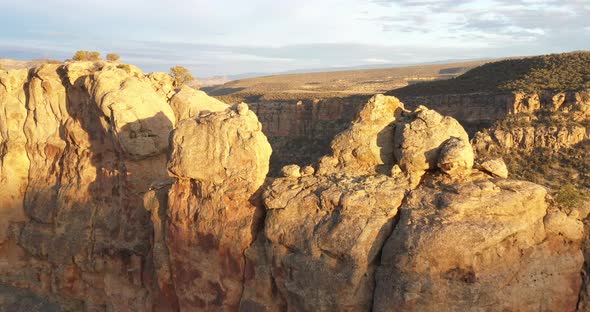 Aerial view of Colorado butte at sunset with drone video going near rocks.