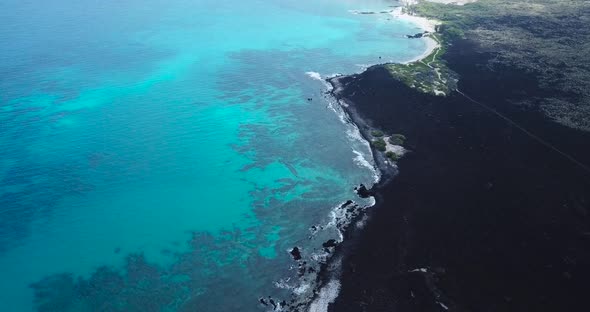 The black sand complimented by the Turquoise water of Hawaii.