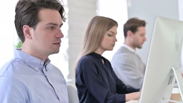 Creative People Using Desktop and Smiling at the Camera