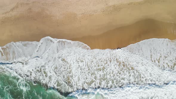 Top-down still aerial shot of the waves crashing on the California Coast near Montara.