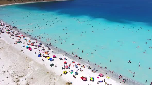 People Swim on Vacation in the White Sandy Beach of the Clear Tropical Turquoise Light Blue Sea