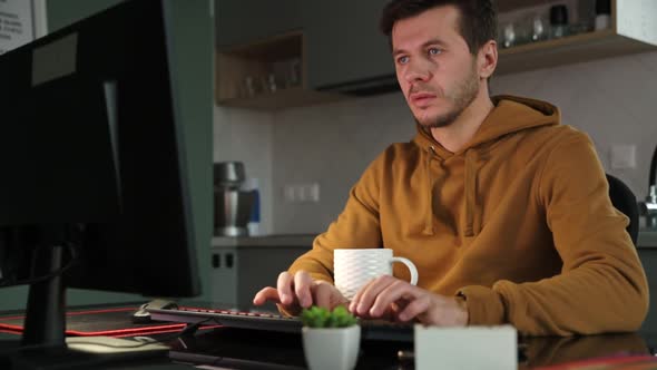 Man Works at Home Office Remotely Using Computer