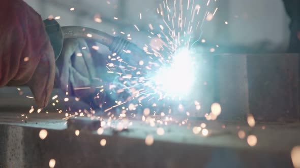 Slow motion of a welder welding construction steel frames