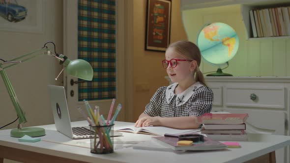 Schoolgirl in Eye Glasses Learning Online at Home