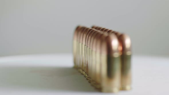 Close up of many ammunition are arranged in a row and rotated with a rotating platform. Slow Motion