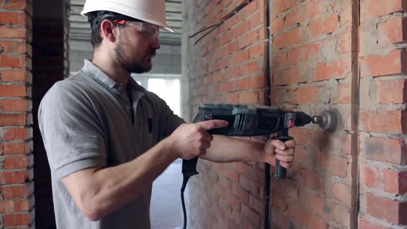 A man builder at a construction site works as a performer.