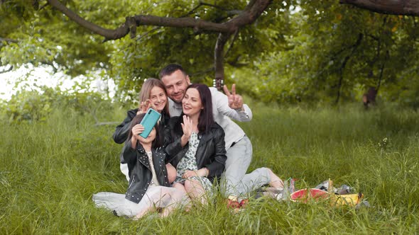 Cheerful Caucasian Family of Four Taking Selfie on Modern Smartphone During