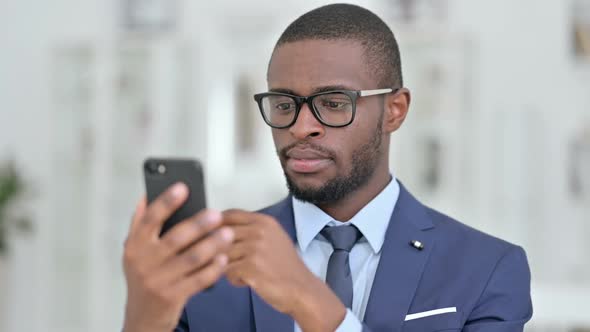 Portrait of Serious African Businessman Using Smartphone