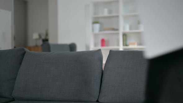 Young Professional Man Coming in and Sitting at Home