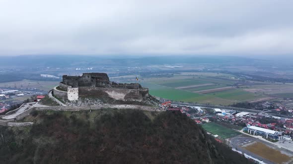 Stunning Aerial View of the Medieval Stone Fortress of Deva on a Cloudy Day