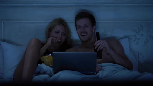 Sweet Husband and Wife Watching Show on Laptop, Smiling and Talking, Happiness