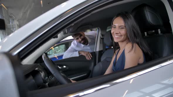 Happy Female in Car During Visit To Auto Showroom