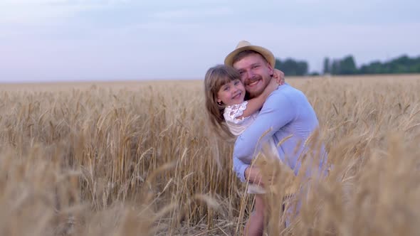 Family Relationships, Happy Man Cheerfully Hugs Little Joyful Girl and Smile on Field with Ripe