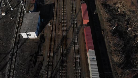 Aerial View of a Large Train on the Rails Next To the River. The Camera Flies Over a Long Train of