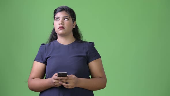 Young Overweight Beautiful Indian Businesswoman Against Green Background